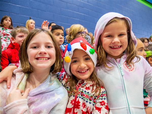 Students in holiday clothes doing festive things at school. 
